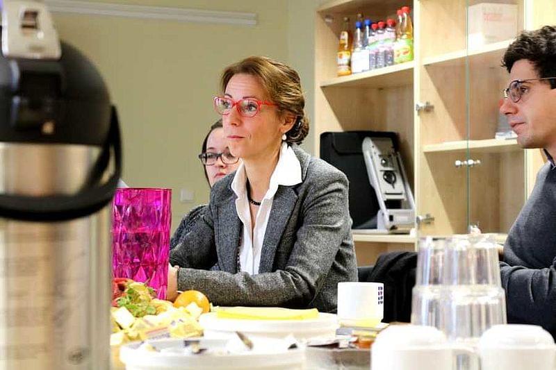 Drei Personen sitzen am Tisch. Vor sich verschiedene Getränke und Obst.