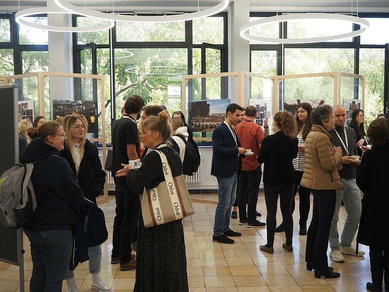 several people talking in the foyer of House 19