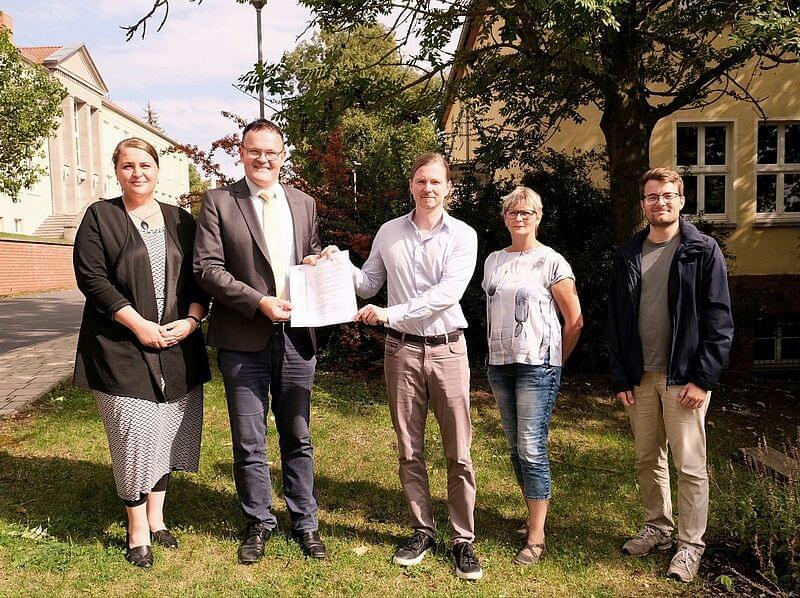 fünf Personen mit dem Partnerschaftsvertrag