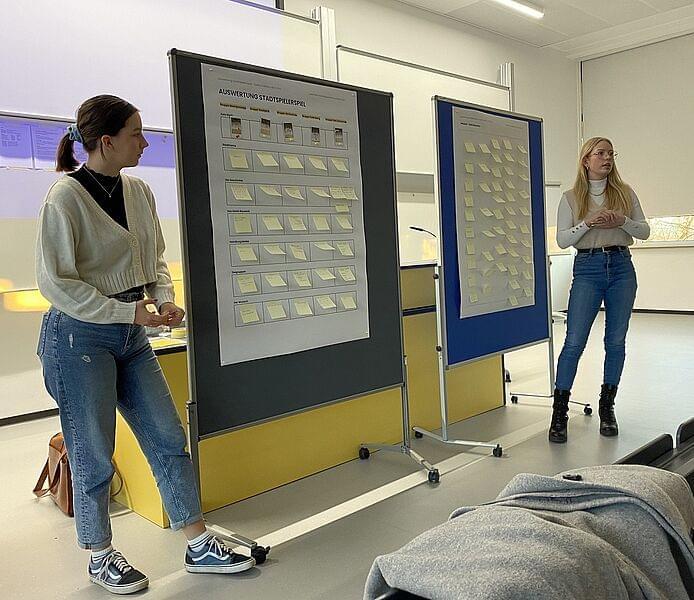 zwei Studierende mit der Auswertung an einem Flipchart
