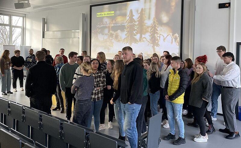 Gruppe von Menschen vor einem Videobildschirm