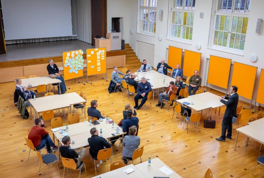 personen an tischen sprechen miteinander in einem audimax