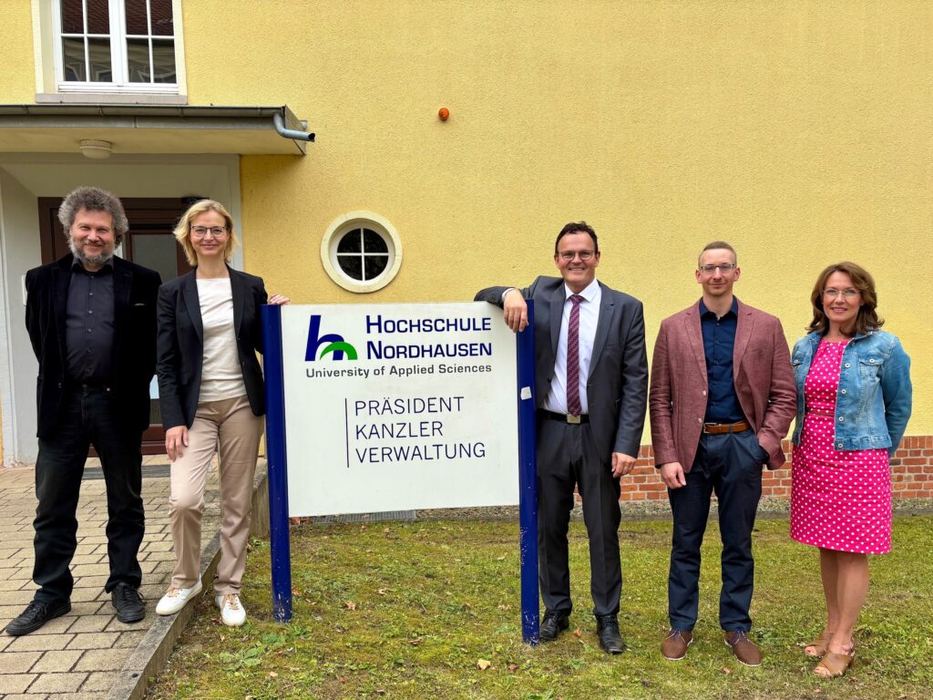 a group of people standing in front of a building holding a sign
