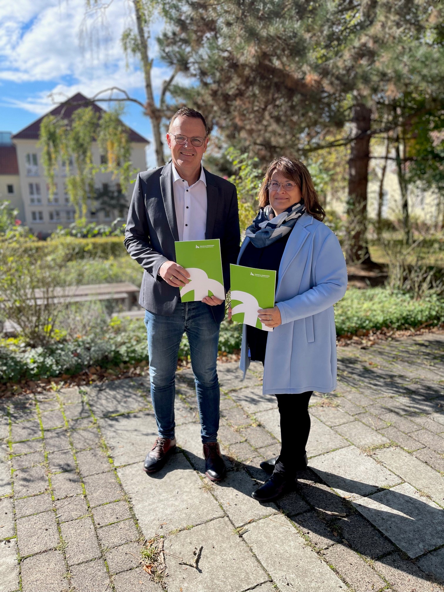 Two people with documents outdoors.