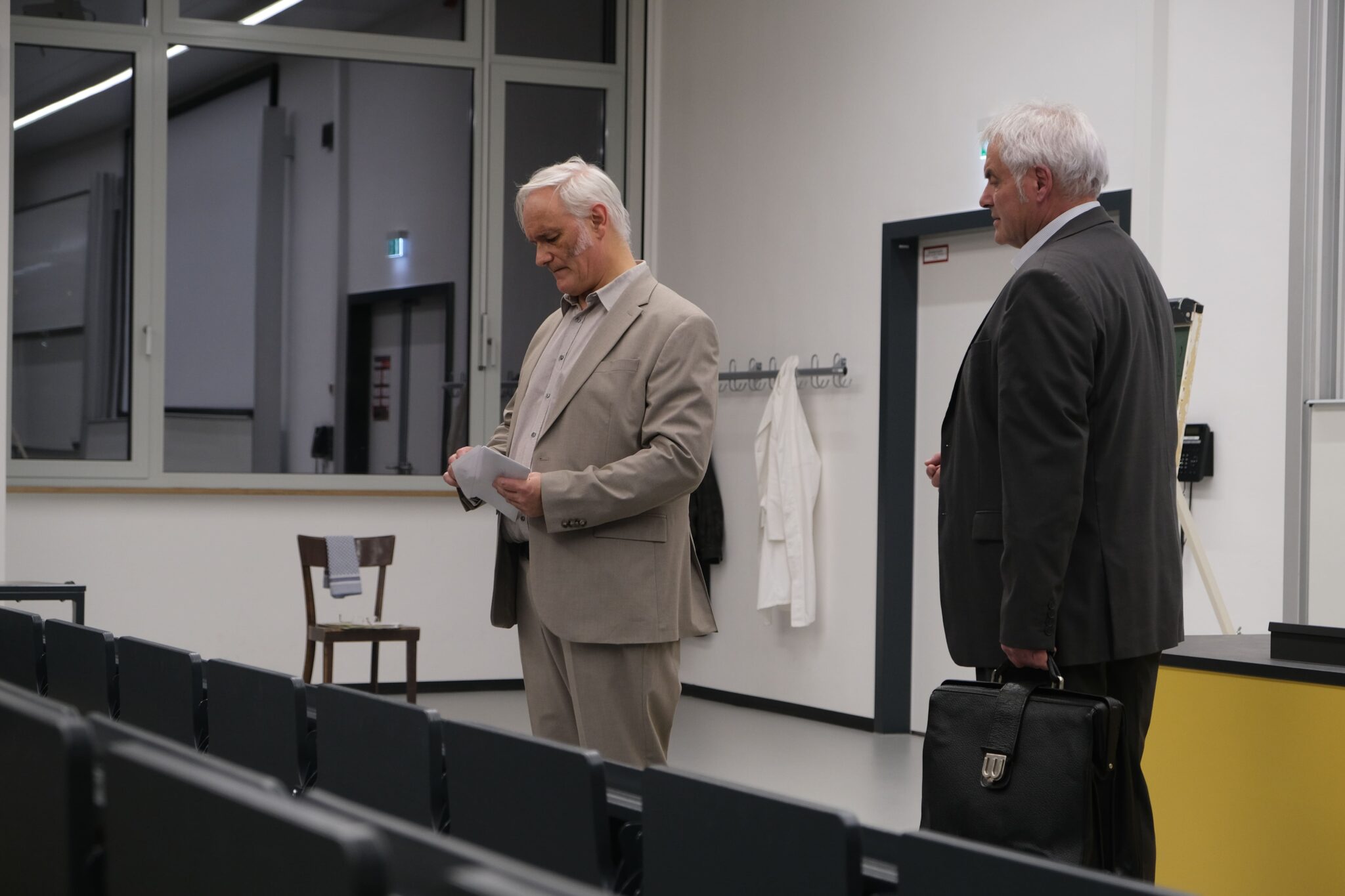 Two men in a meeting room.