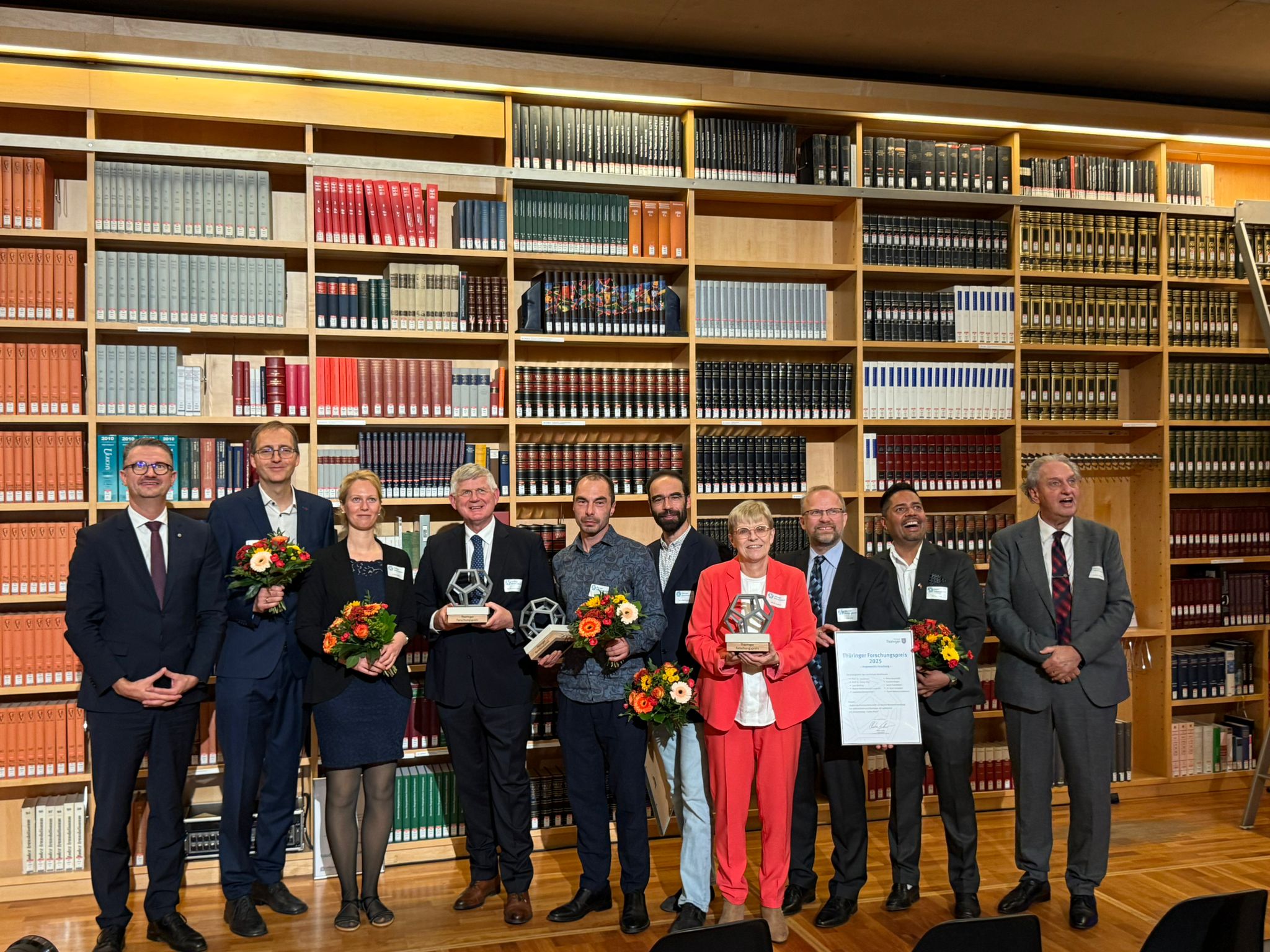 Group photo with awards and flowers.