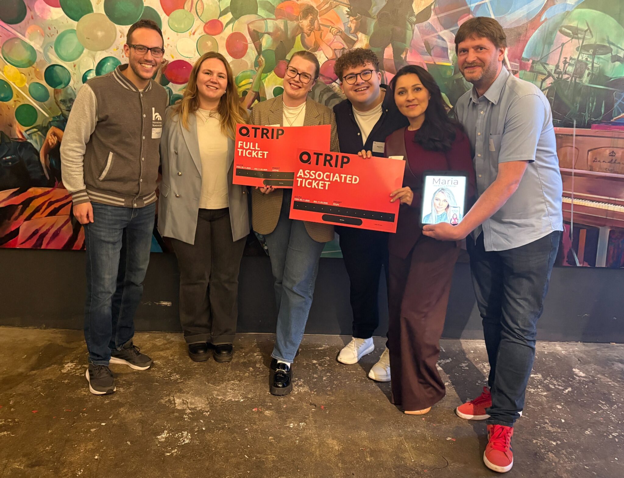 Group with tickets in front of artwork