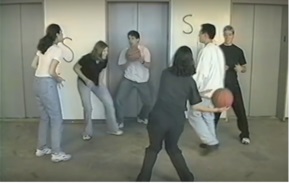 Eine Gruppe von Personen spielt sich einen Basketball zu.