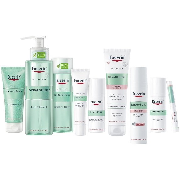 Nine different products from the DermoPure skincare range are lined up next to each other, including cleansing gel, facial tonic, serum and mattifying fluid. The packaging is white with a central turquoise-coloured band and the red Eucerin logo