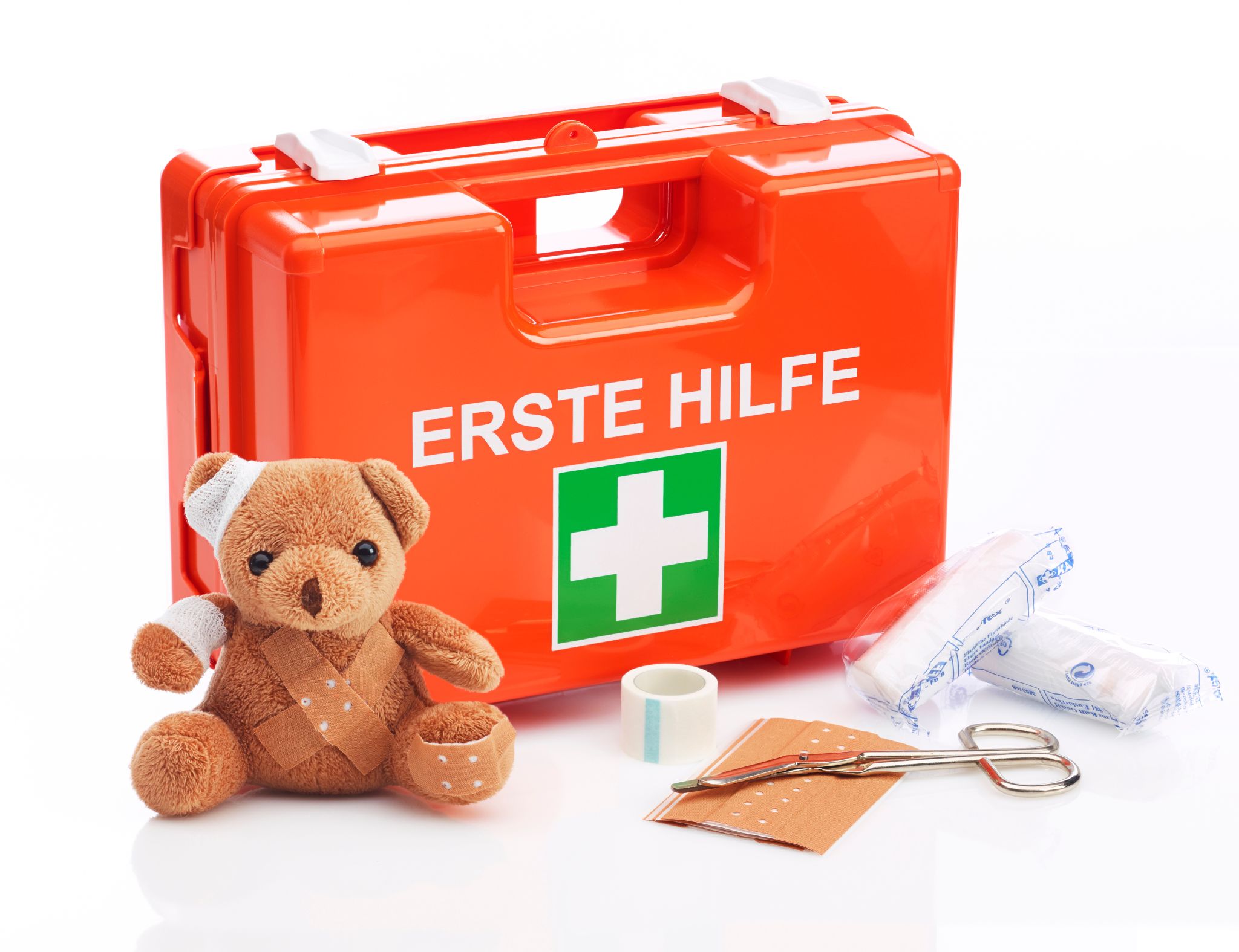 Erste-Hilfe-Kasten mit Teddy und Verbandskasten sowie Verbandszeug wie Schere und Heftpflaster