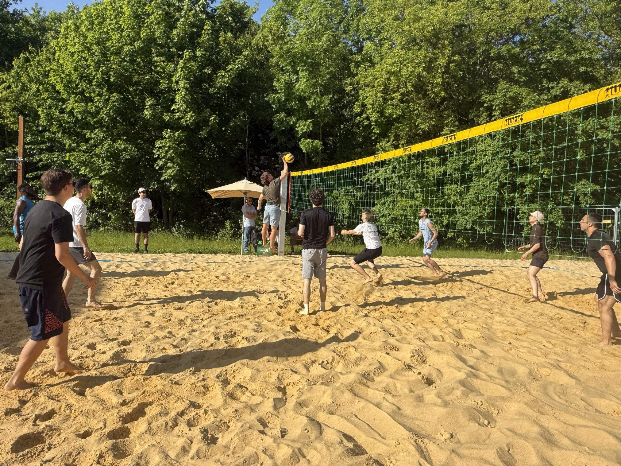 Students play beach volleyball in the sand